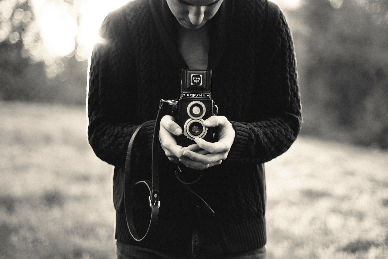 A young person holding an old film camera.