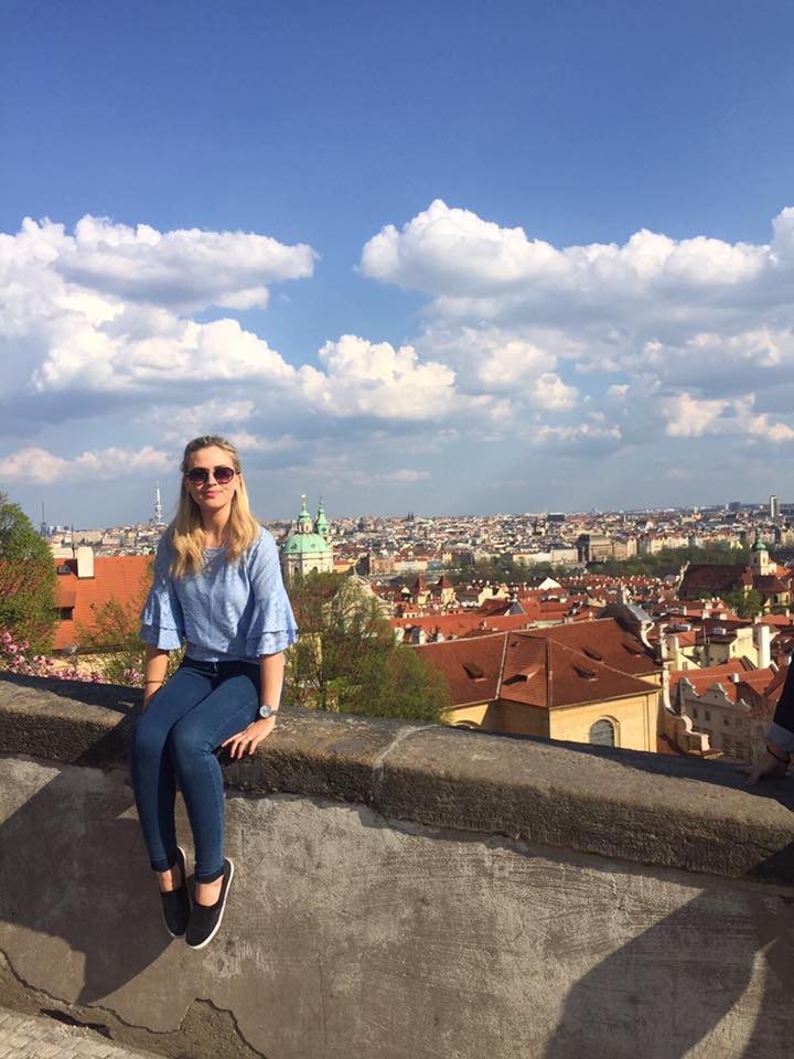 Jenna sitting on a wall overlooking Prague