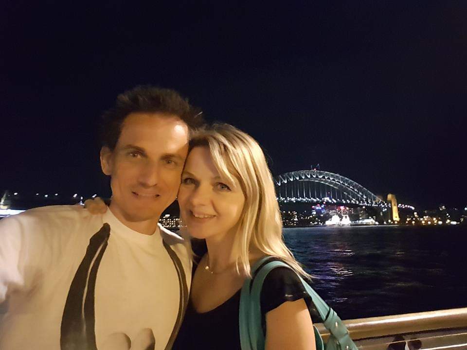 Couple smiling in front of Sydney Harbour bridge 