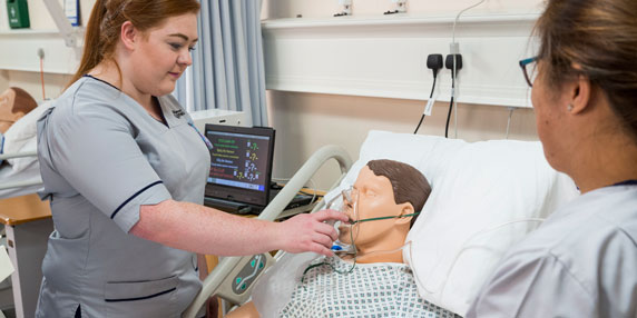 A nursing student practicing on a dummy